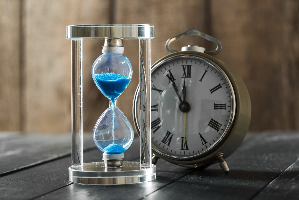 Time is passing. Blue hourglass close up